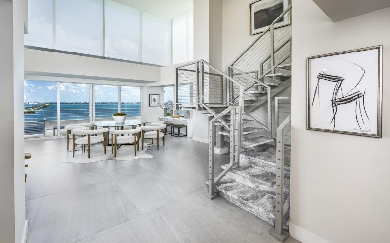 a room with a staircase and tables