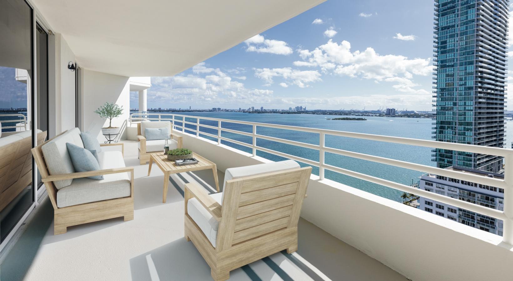 a balcony with a couch and chair overlooking a body of water